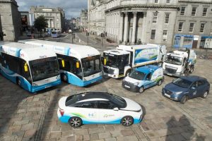 Alt text: Several buses and cars parked on a street.