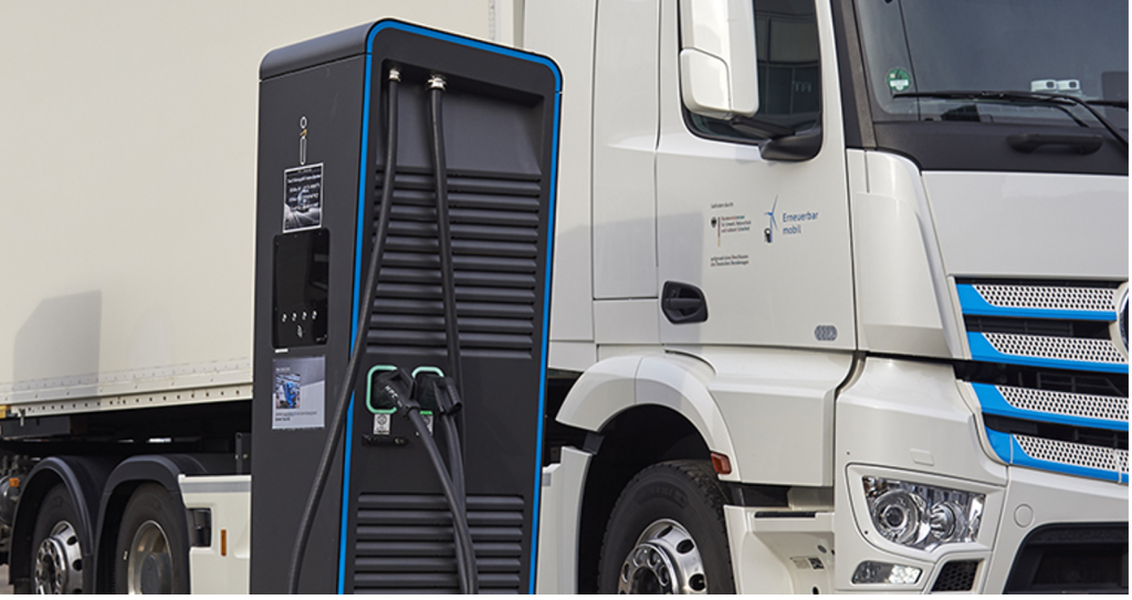 Alt text: A white truck parked next to a black charging point.